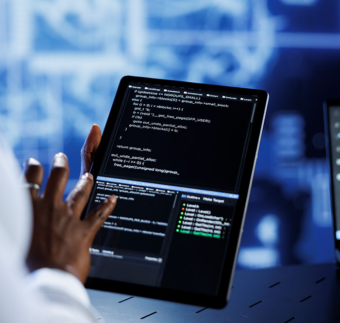 Homme tenant une tablette avec du code de Offbeat - Agence digitale créative au Sénégal